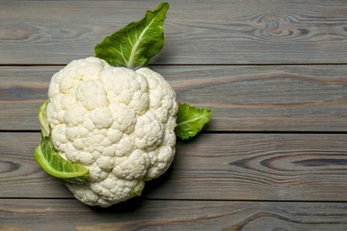 Whole fresh raw cauliflower on wooden table, top view. Space for text