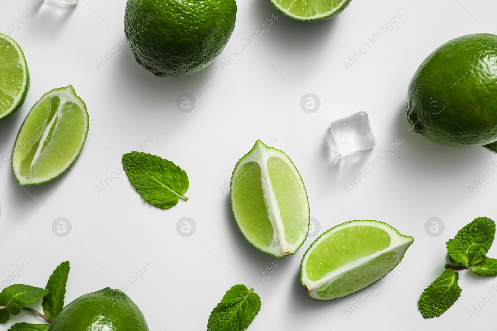 Photo of Flat lay composition with fresh juicy limes, mint and ice cubes on white background