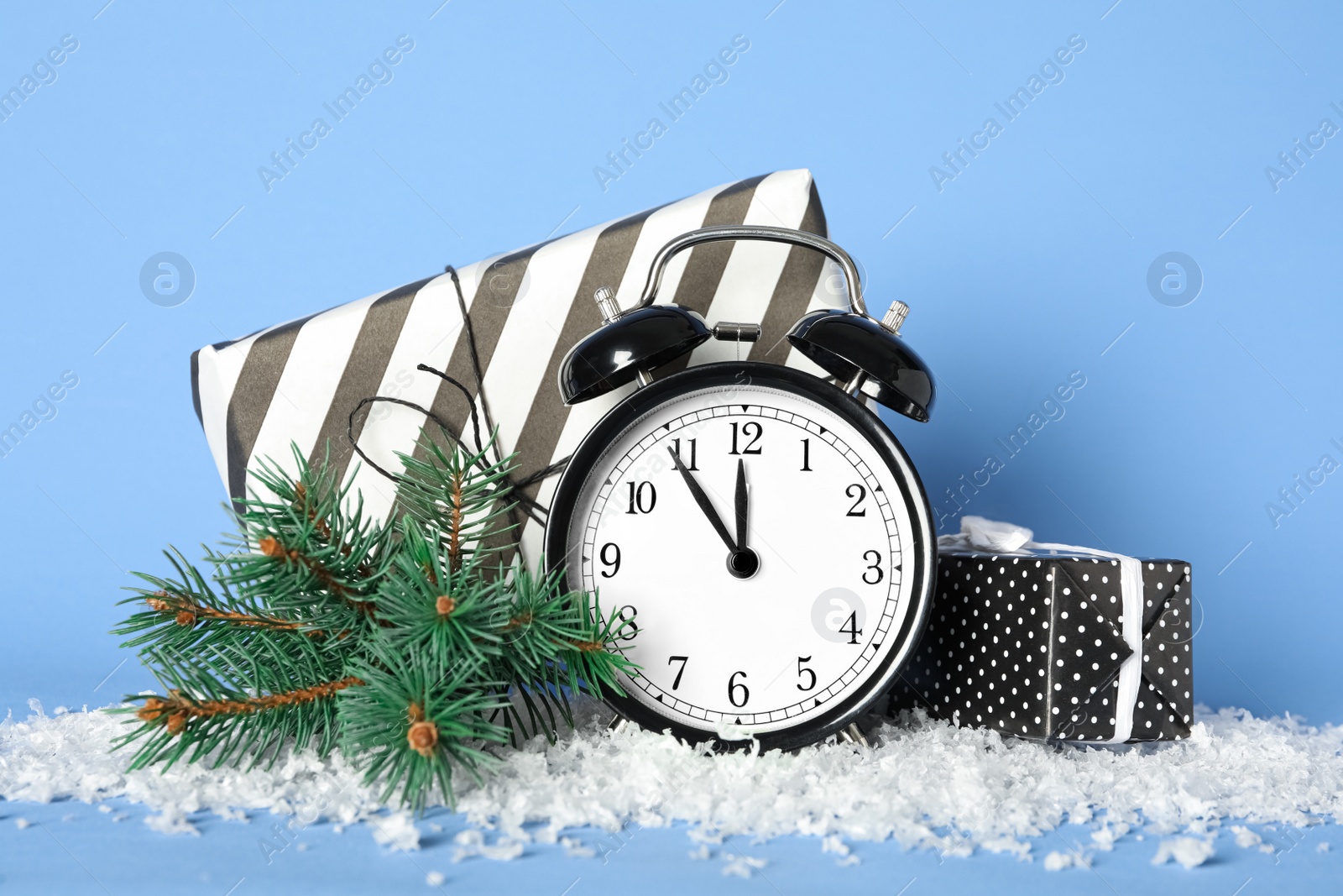 Photo of Vintage alarm clock with Christmas decor on light blue background. New Year countdown