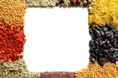 Frame made of different aromatic spices on white background, top view with space for text