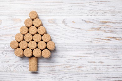 Christmas tree made of wine corks on white wooden table, top view. Space for text