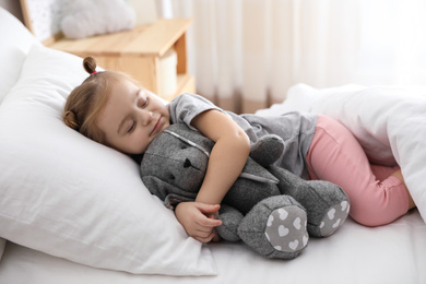 Cute little girl sleeping with toy bunny at home. Bedtime schedule
