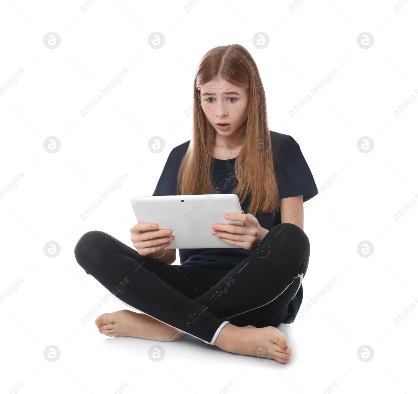 Photo of Shocked teenage girl with tablet on white background. Danger of internet