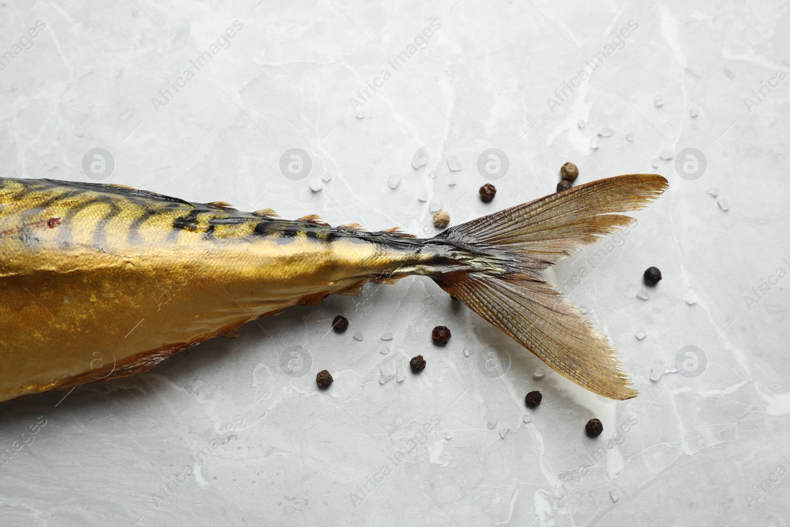 Photo of Tasty smoked fish on light grey marble table, closeup