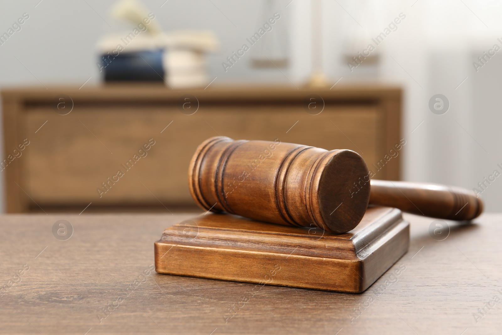 Photo of Wooden gavel and sound block on table indoors, closeup. Space for text