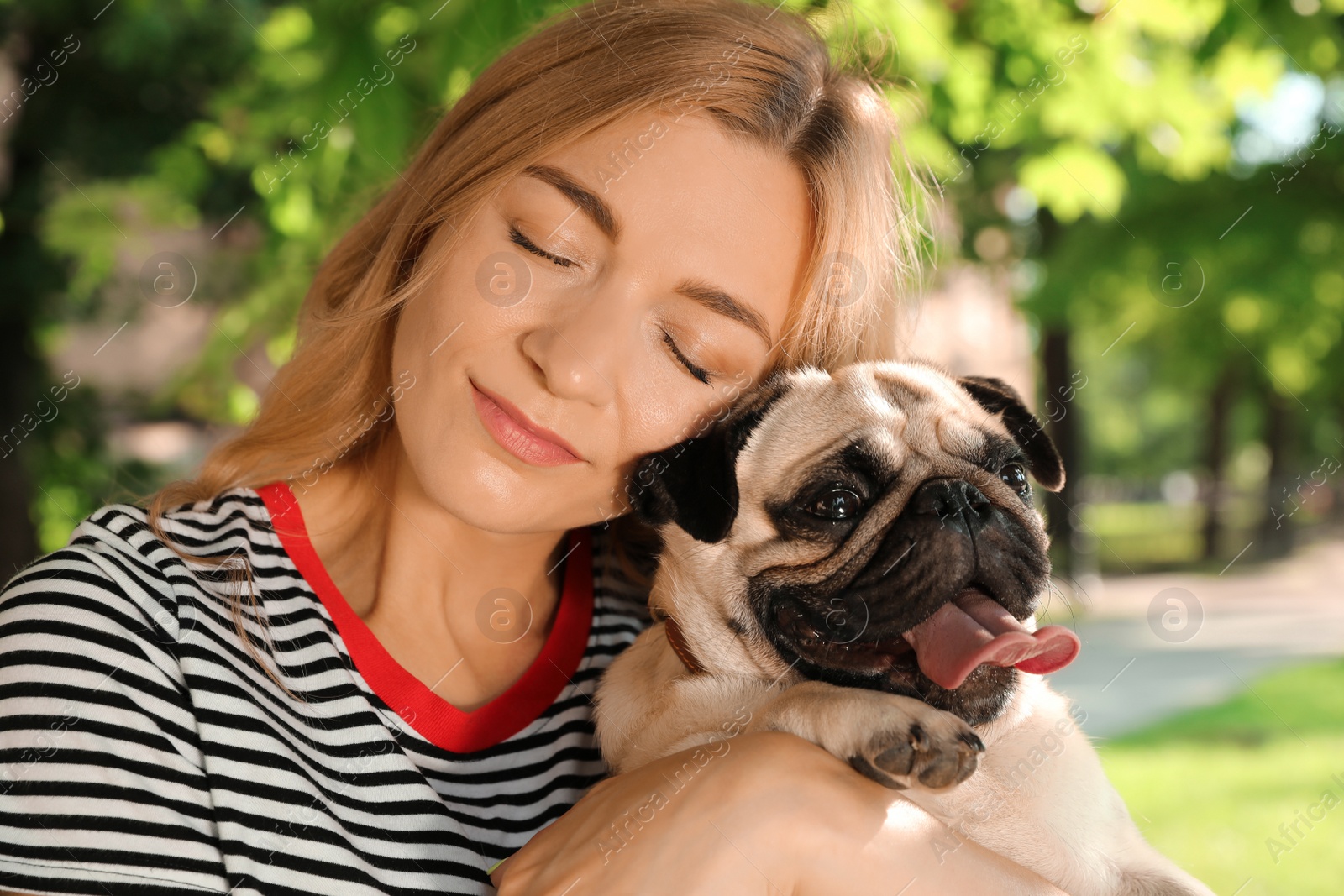 Photo of Woman with cute pug dog outdoors on sunny day. Animal adoption