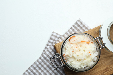 Photo of Tasty fermented cabbage on white table, top view. Space for text