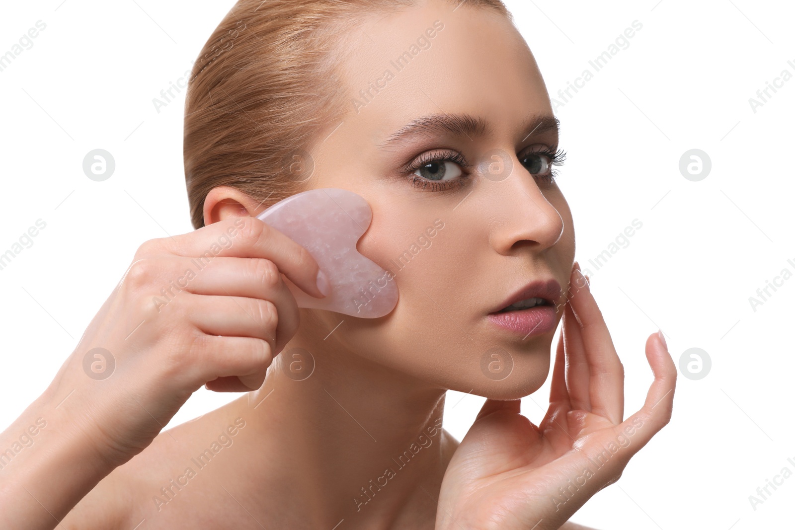 Photo of Beautiful young woman doing facial massage with gua sha tool on white background, closeup