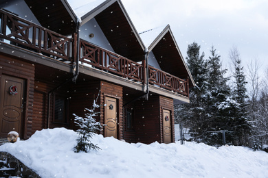 Photo of Modern wooden hotel covered with snow. Winter vacation