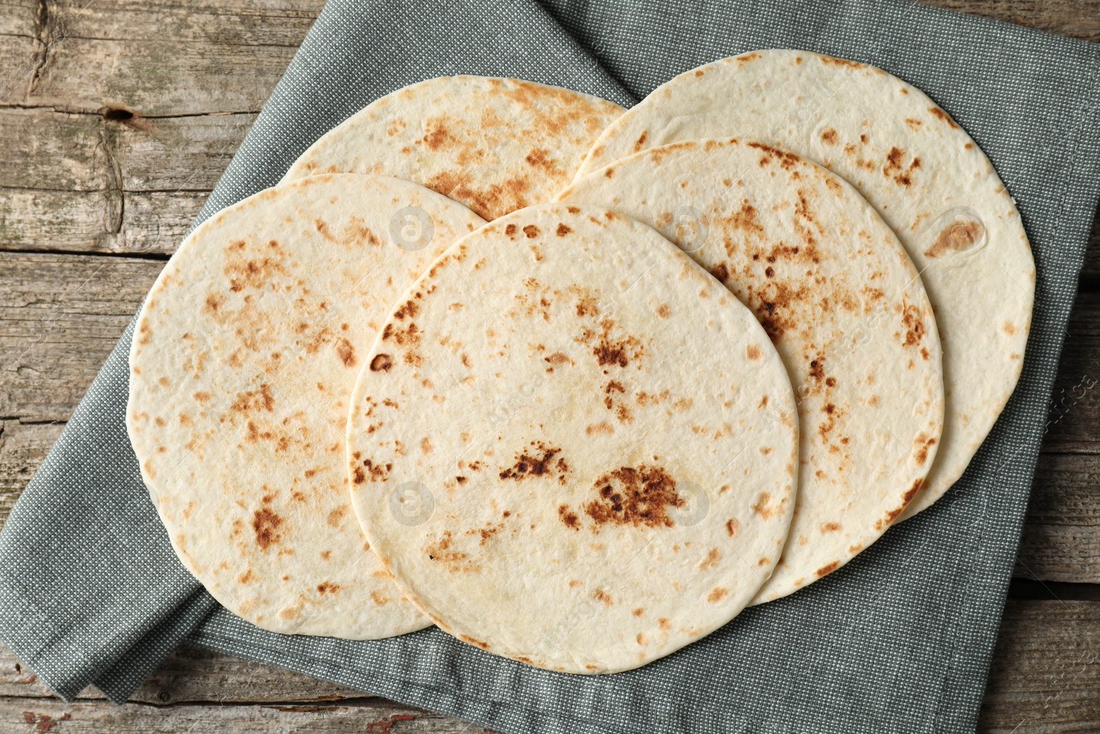 Photo of Tasty homemade tortillas on wooden table, top view