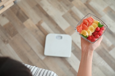 Photo of Woman holding bowl with delicious organic meal, top view. Healthy diet