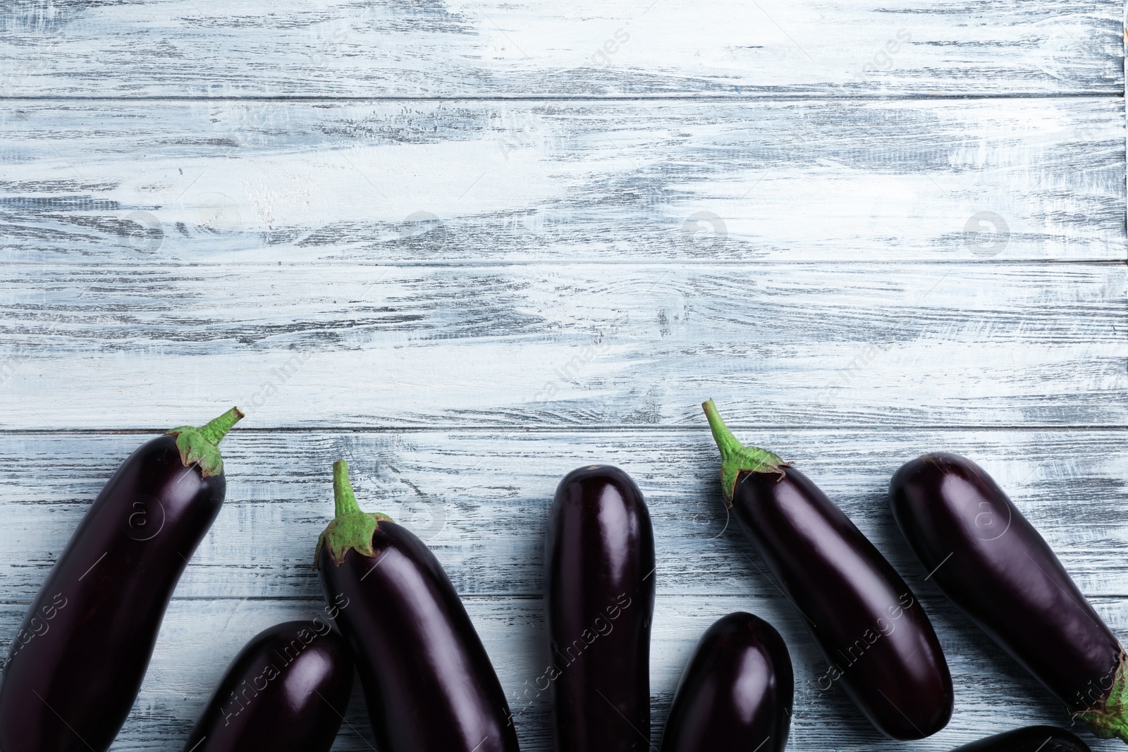 Photo of Raw ripe eggplants on wooden background, top view