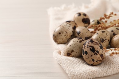 Photo of Fresh quail eggs on white wooden table. Space for text