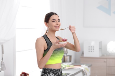 Photo of Young woman in fitness clothes having healthy breakfast at home