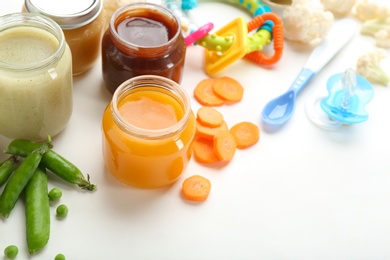 Photo of Jars with tasty baby food on white background