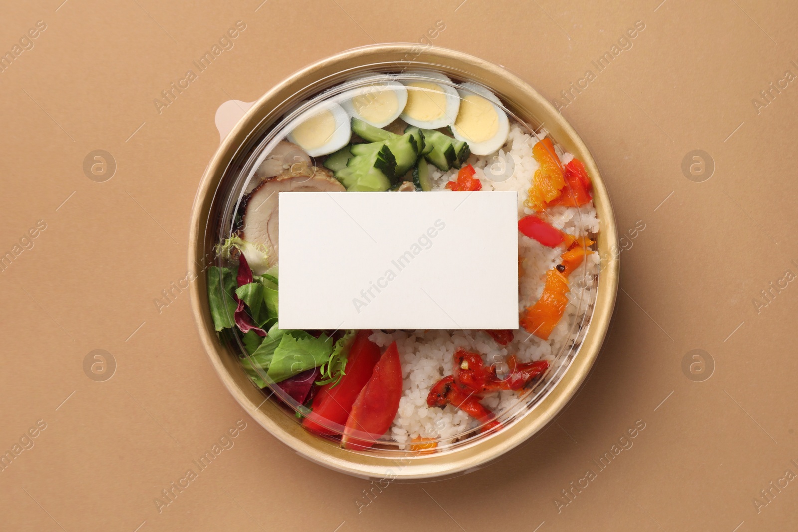 Photo of Tasty food in container on beige background, top view. Space for text