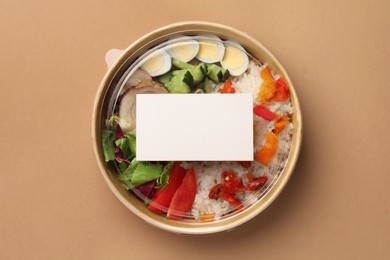 Tasty food in container on beige background, top view. Space for text