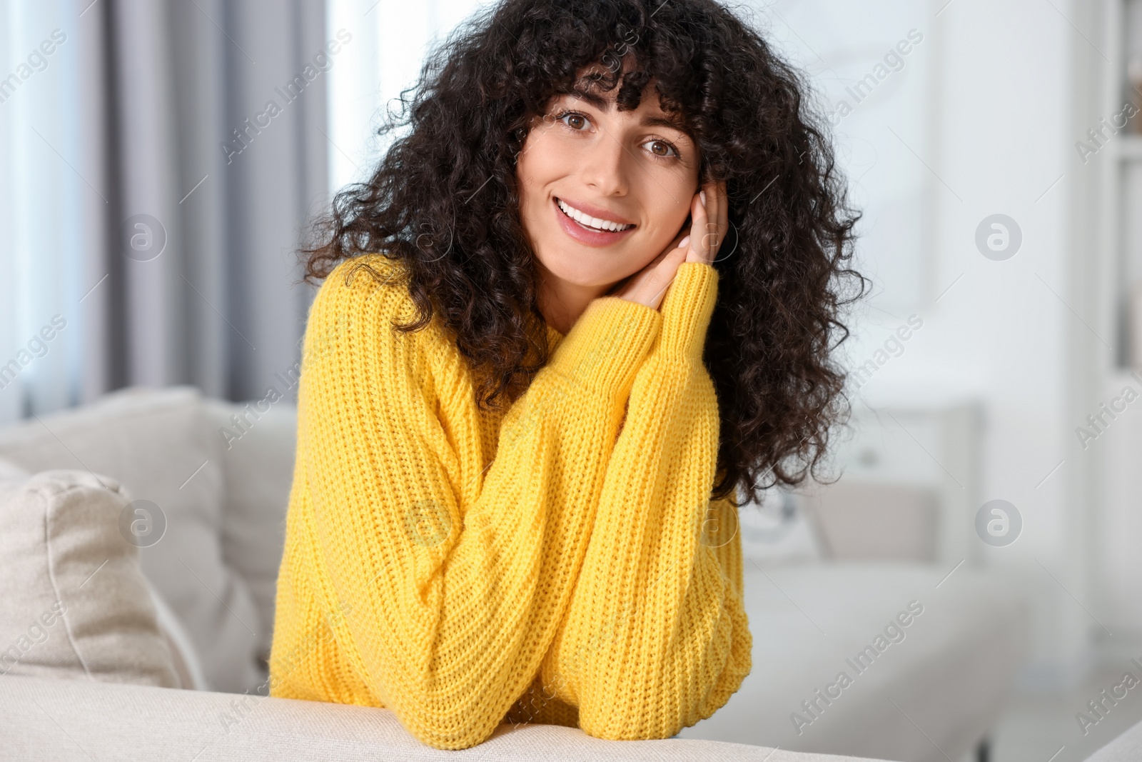 Photo of Happy young woman in stylish yellow sweater indoors