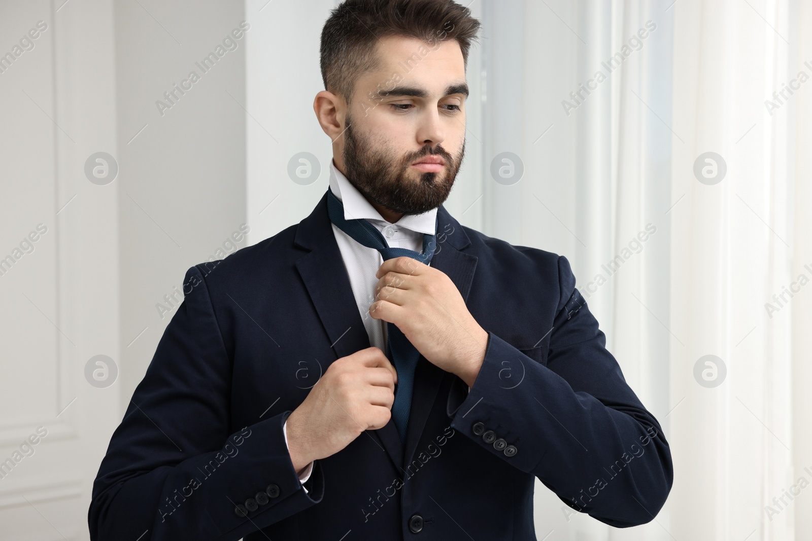 Photo of Handsome businessman in suit and necktie indoors