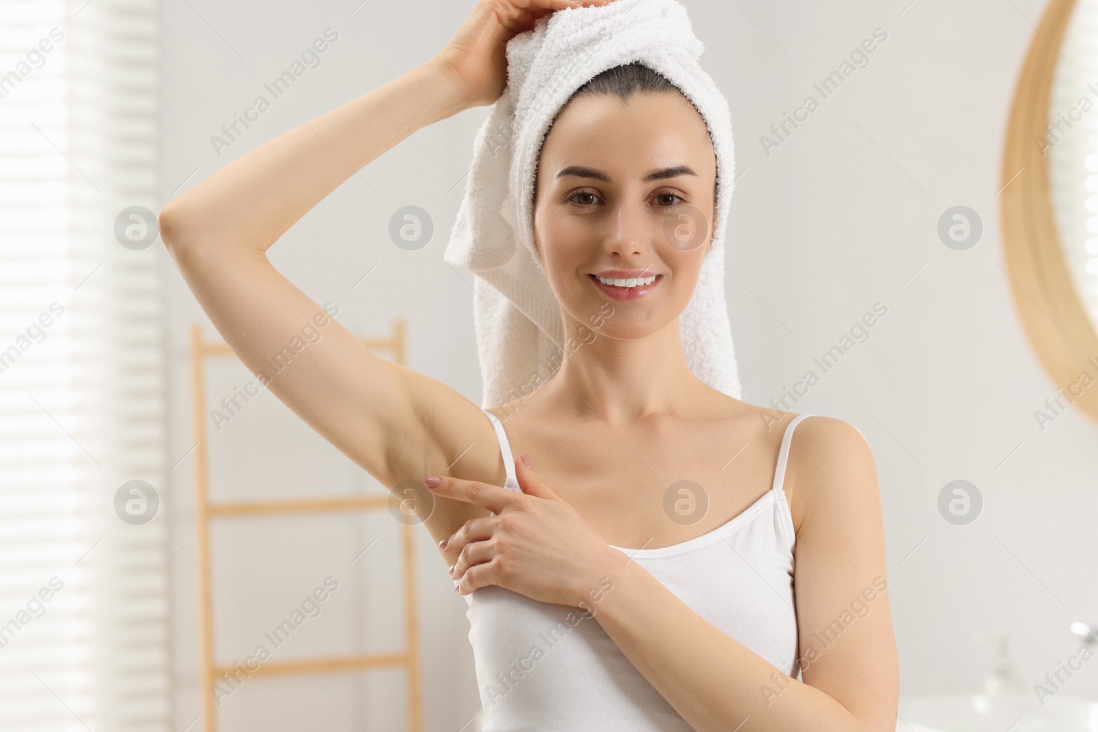 Photo of Beautiful woman showing armpit with smooth clean skin in bathroom