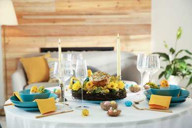 Photo of Festive Easter table setting with beautiful floral decor and eggs indoors