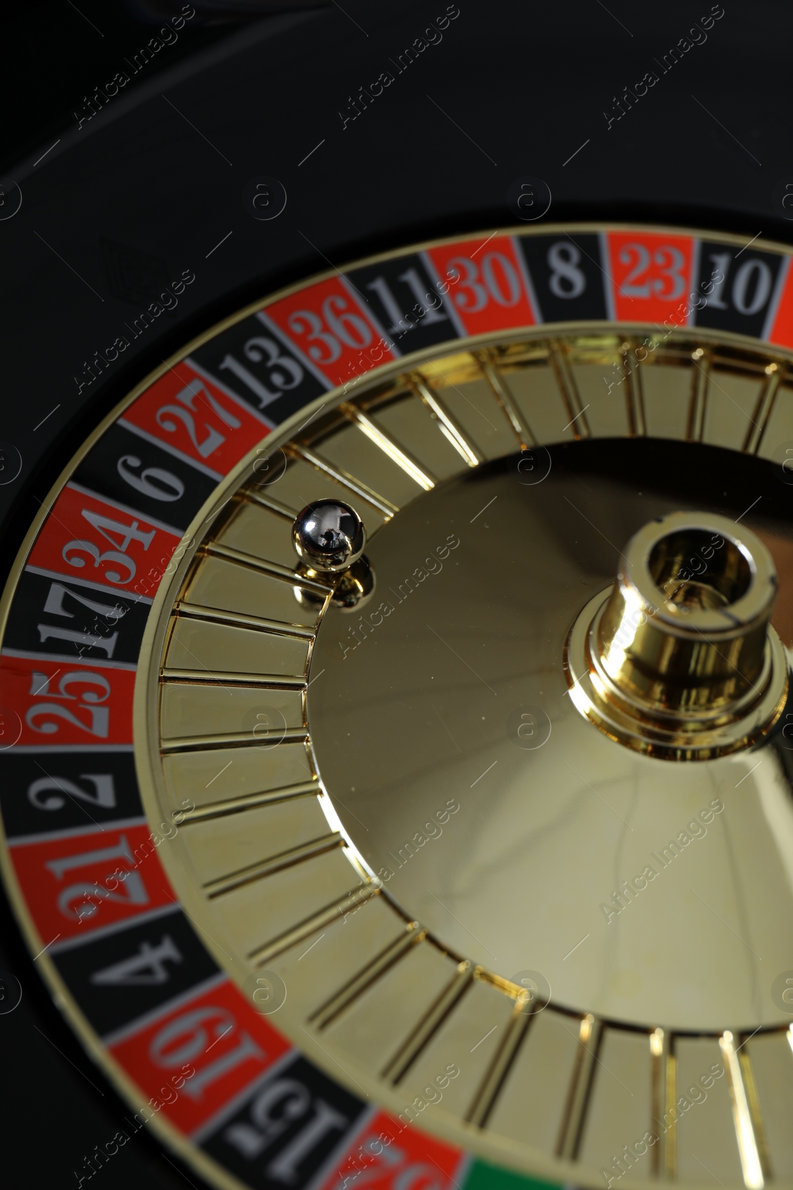 Photo of Roulette wheel with ball, closeup. Casino game