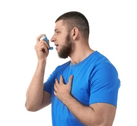 Photo of Young man using asthma inhaler on white background