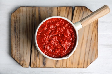 Photo of Delicious tomato sauce in pan on white wooden table, top view