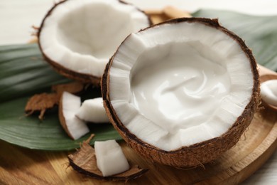 Photo of Ripe coconut with cream on wooden board
