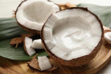 Ripe coconut with cream on wooden board