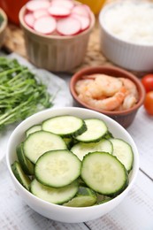 Photo of Ingredients for poke bowl on white wooden table, closeup