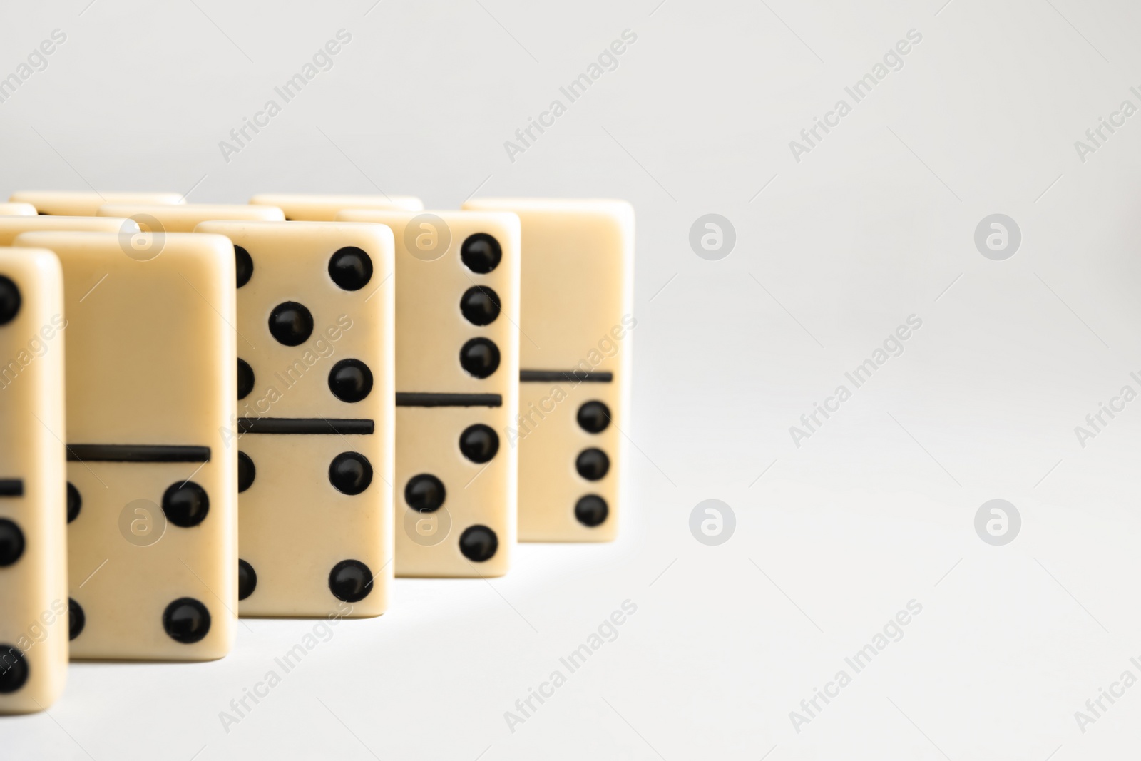 Photo of Domino tiles on white background. Space for text