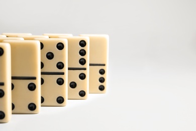 Photo of Domino tiles on white background. Space for text