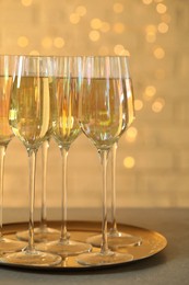 Glasses of champagne served on grey table
