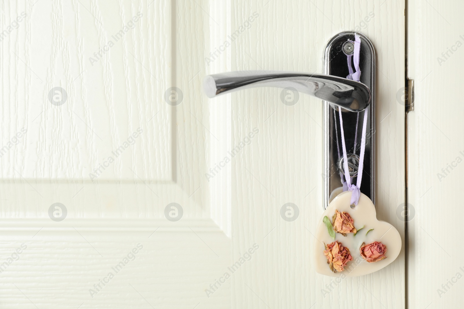 Photo of Scented sachet with flowers hanging on door handle