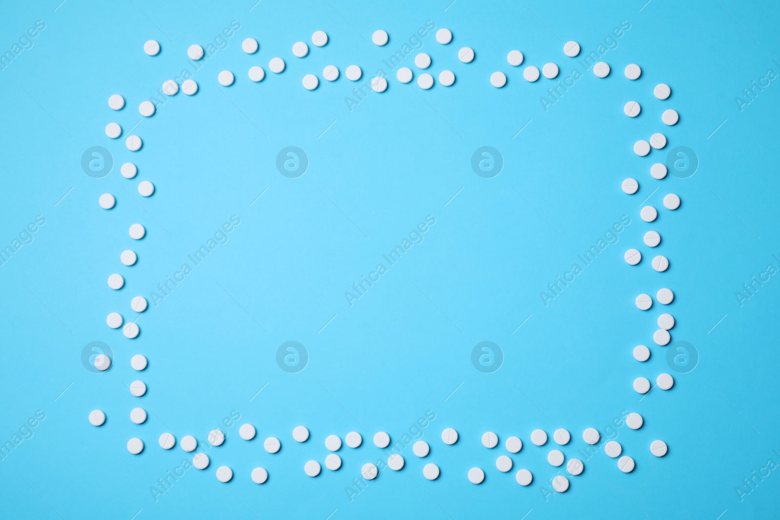 Photo of Frame of pills on light blue background, flat lay. Space for text