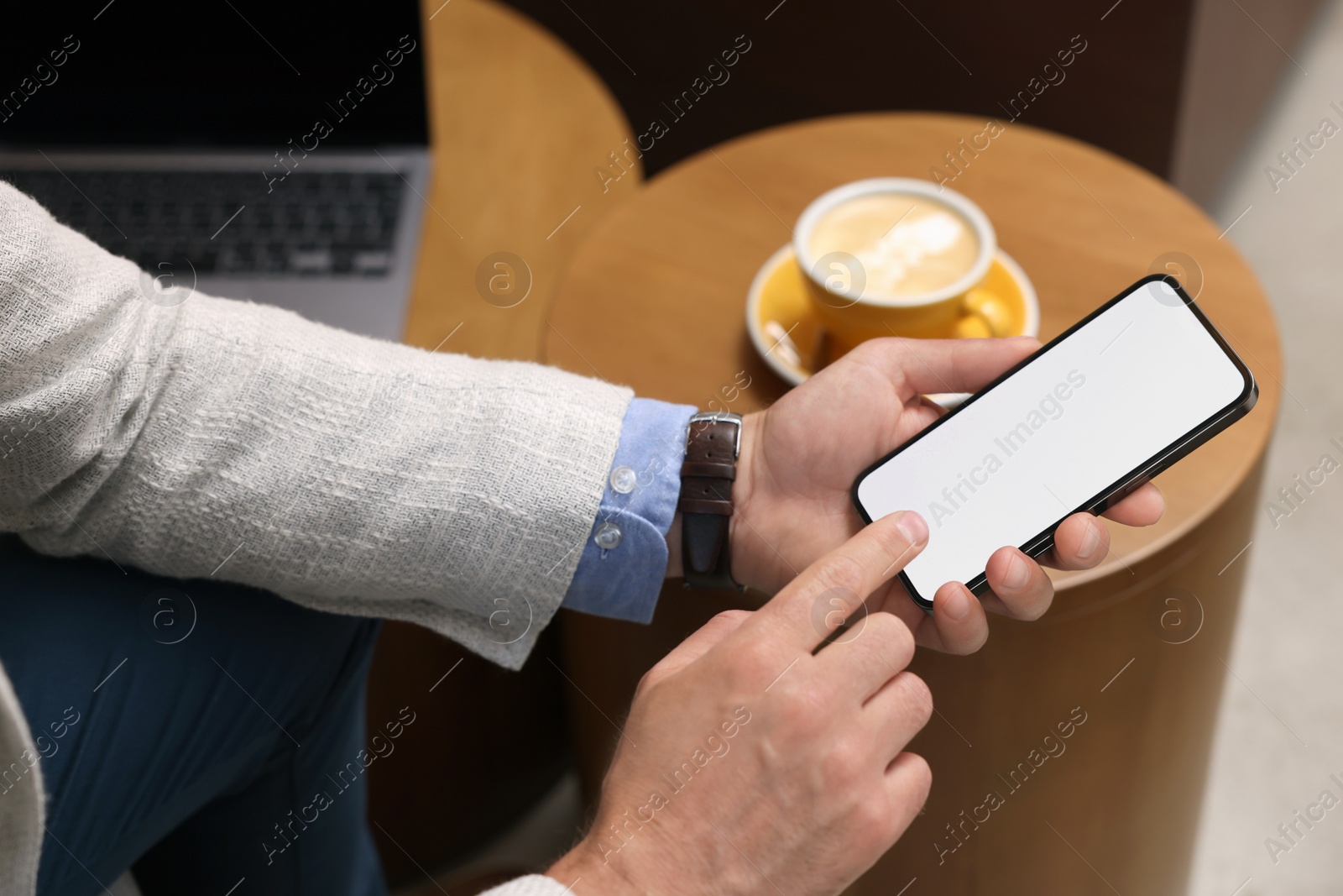 Photo of Man using mobile phone at table, closeup