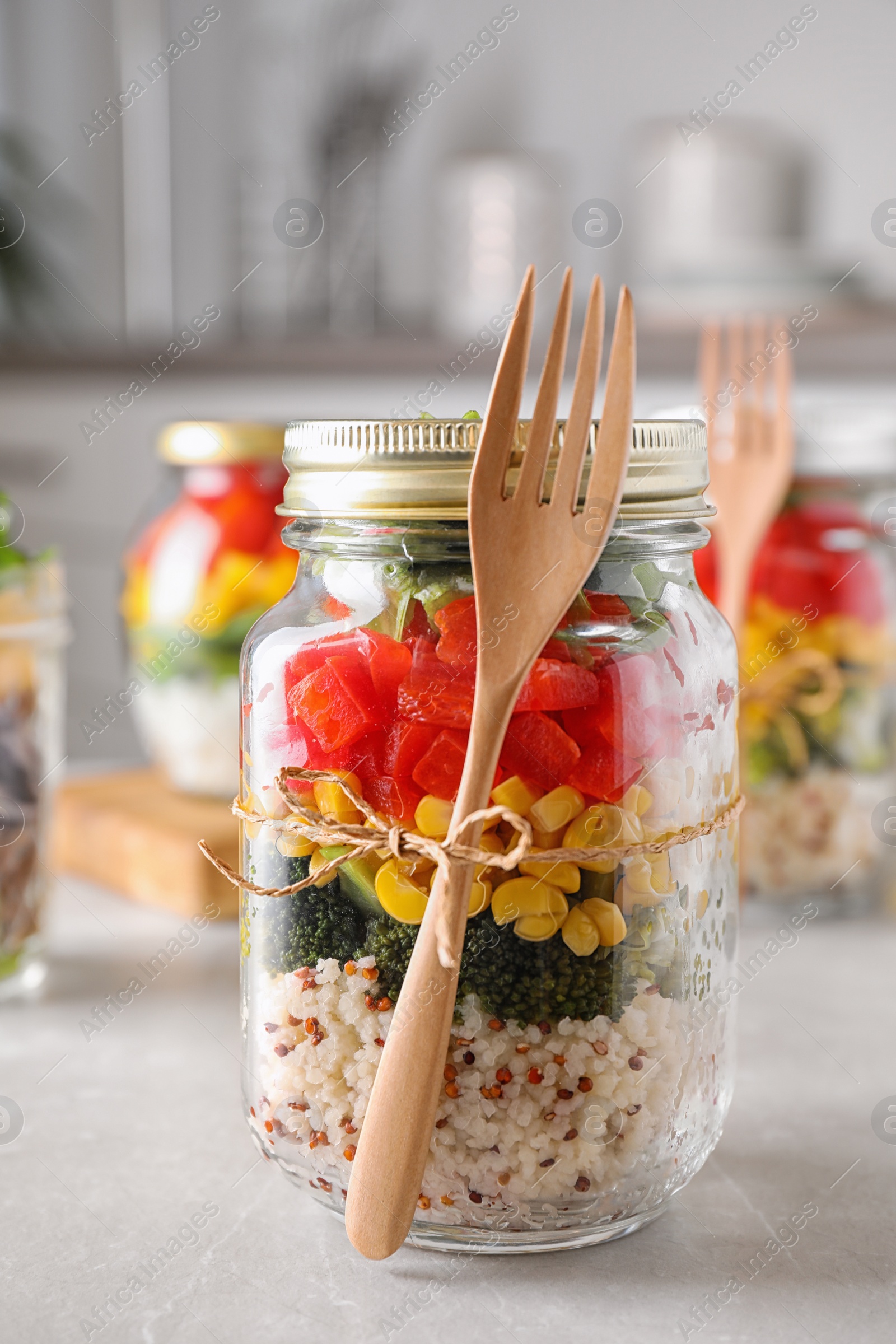 Photo of Glass jar with healthy meal on light grey marble table