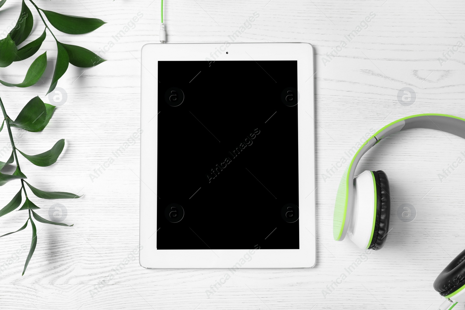 Photo of Flat lay composition with headphones and tablet on white wooden background. Space for text