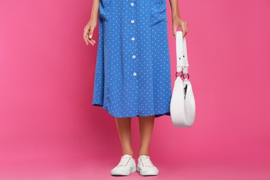 Photo of Woman with stylish bag on pink background, closeup