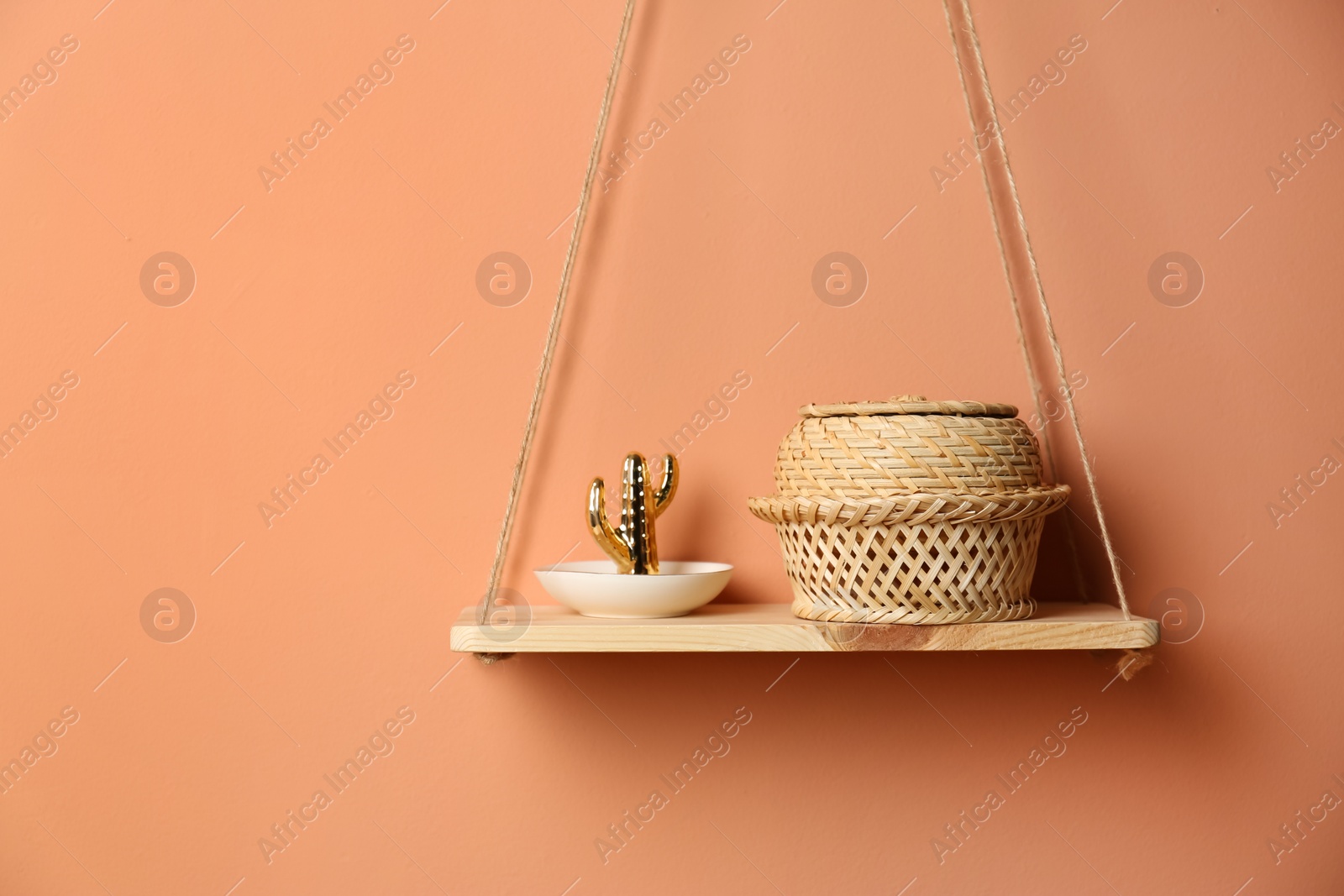 Photo of Shelf with stylish decor on brown wall. Interior design