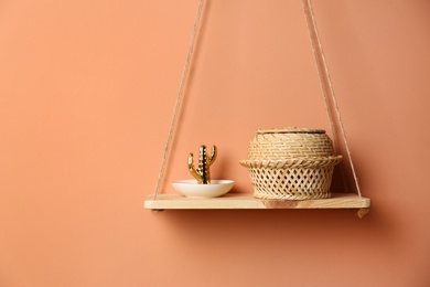 Photo of Shelf with stylish decor on brown wall. Interior design