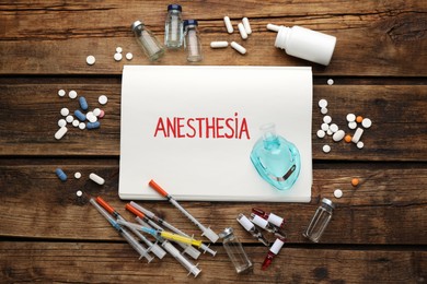 Photo of Flat lay composition of notebook with word Anesthesia and drugs on wooden table
