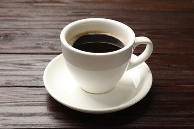 Cup of aromatic coffee on wooden table, closeup