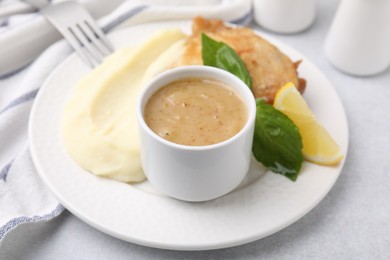 Photo of Delicious turkey gravy served on light grey table, closeup