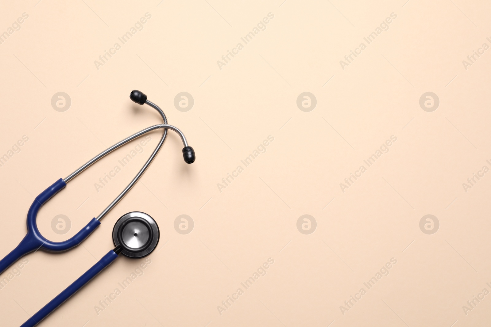 Photo of Stethoscope on beige background, top view. Space for text