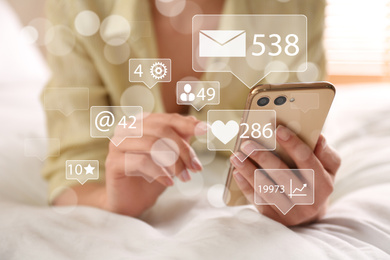 Image of Woman using modern smartphone on bed at home, closeup. Social media marketing