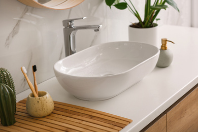 Stylish vessel sink on light countertop in modern bathroom