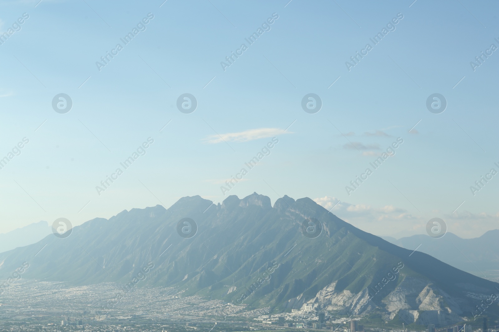 Photo of Big mountains and city under blue sky on sunny day
