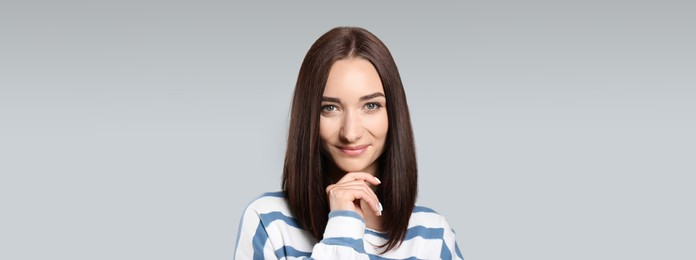 Image of Portrait of pretty young woman with gorgeous chestnut hair on light grey background. Horizontal banner design